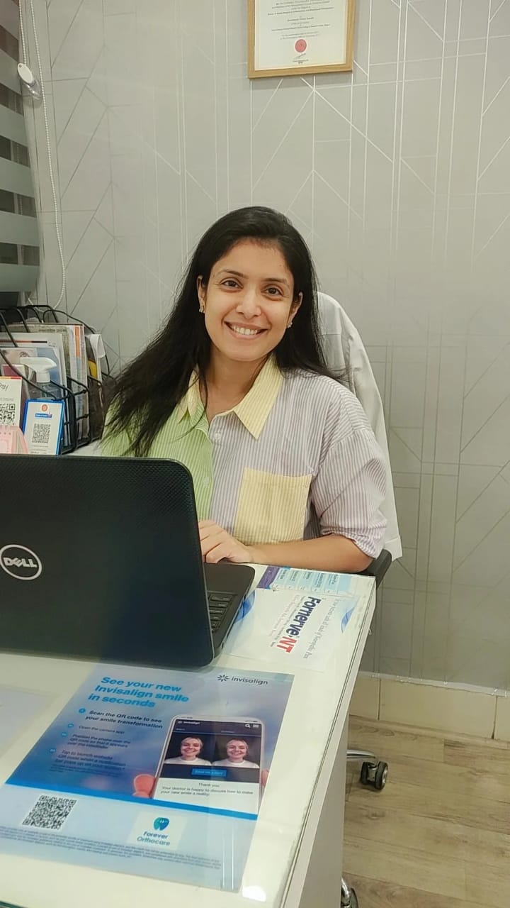 Dr. Honey sitting on chair infront of open laptop at forever orthocare dental clinic in nagpur