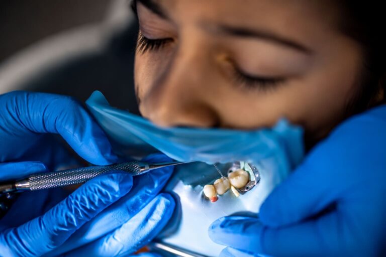 Professional dental technician creating a custom dental crown in a modern dental laboratory with precision tools and advanced restorative dentistry techniques.